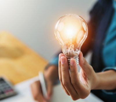 concept save energy power. businesswoman holding light bulb in o concept save energy power. businesswoman holding light bulb in office